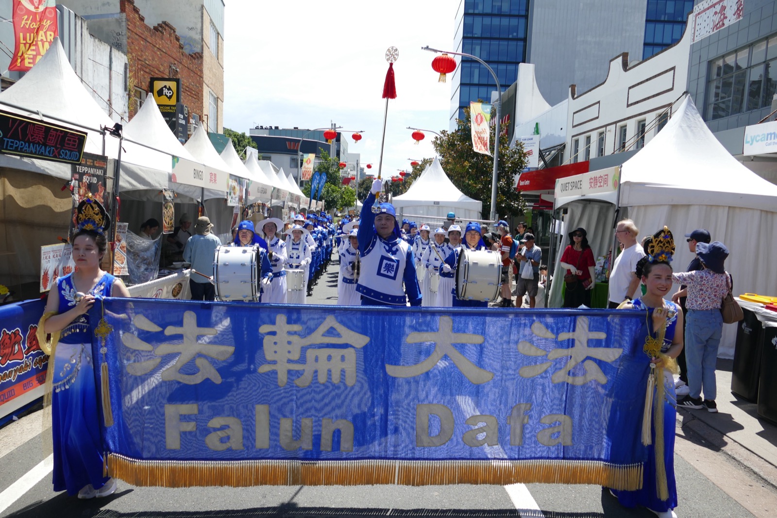 The full band marching behind its banner at the Georges River Lunar New Year Festival